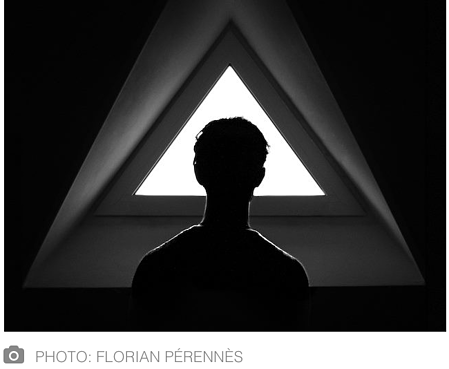 Image of person staring out a triangle window.