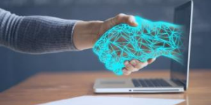 Image of blue hand coming out of laptop screen and shaking a human hand.