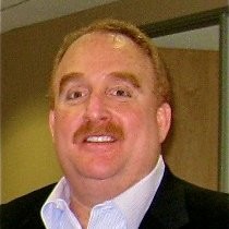 A Caucasian middle-aged man is smiling in a photo.