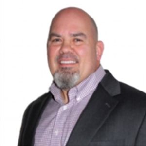 Professional headshot of white male with a dark blazer and smile