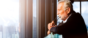 older businessman looking out office window. retirement concept