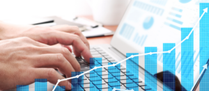 Businessman analyzing data and preparing reports. Laptop and growth graphs.