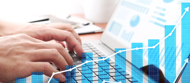 Businessman analyzing data and preparing reports. Laptop and growth graphs.