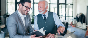 Two coworkers of different ages collaborate together in the workplace.