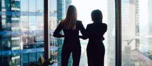 business women looking out skyscraper window