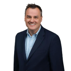 Profile headshot of Derek White in a black suit coat.