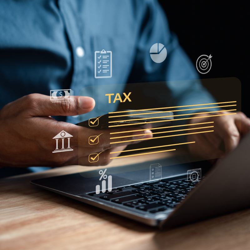 A business man working on his laptop with an overlay wording regarding the tax industry.