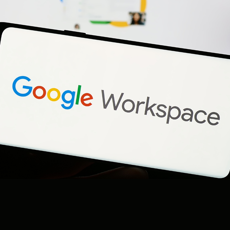 Person holding smartphone with logo of business app software Google Workspace on screen in front of website.