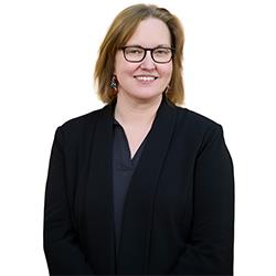Profile headshot of Conor Barnes in a black suit coat.