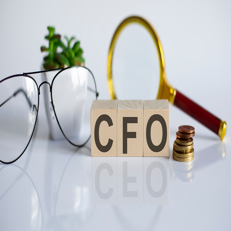 CFO word concept on wooden cubes and flower ,glasses ,coins and magnifier on the white background.