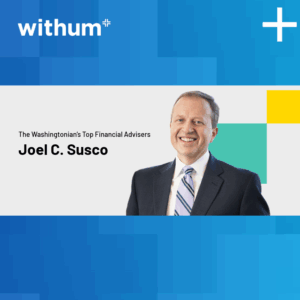 Joel Susco, smiling in a professional headshot. He is wearing a black suit with a white collar shirt and a striped blue tie. The background consist of different shades of blue.