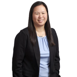 Profile headshot of Cara E. Rossi in a black suit coat and blue tshirt.