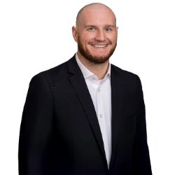 Profile headshot of Anthony Venette in a black suit coat and a white shirt.