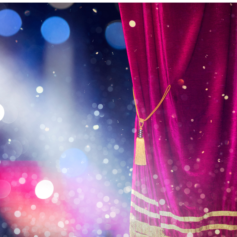 red curtain on theater stage during a production.