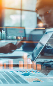 Professional reviewing tax data and financial reports on a laptop with analytics overlay.