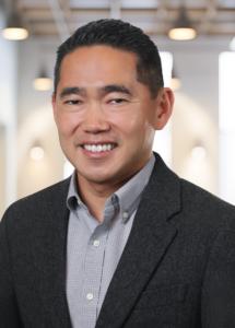 Headshot of Nicholas Murakami in Black blazer and grey shirt. Withum