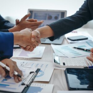 In a business team meeting, success is celebrated with a handshake.