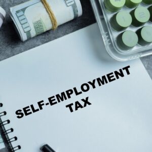 Concept of self-employment tax write on book isolated on Wooden Table. For freelancers and independent contractors with income reporting