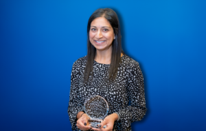 Fatema Raza smiling and holding her NJ Chamber of Commerce Young Professional Award.